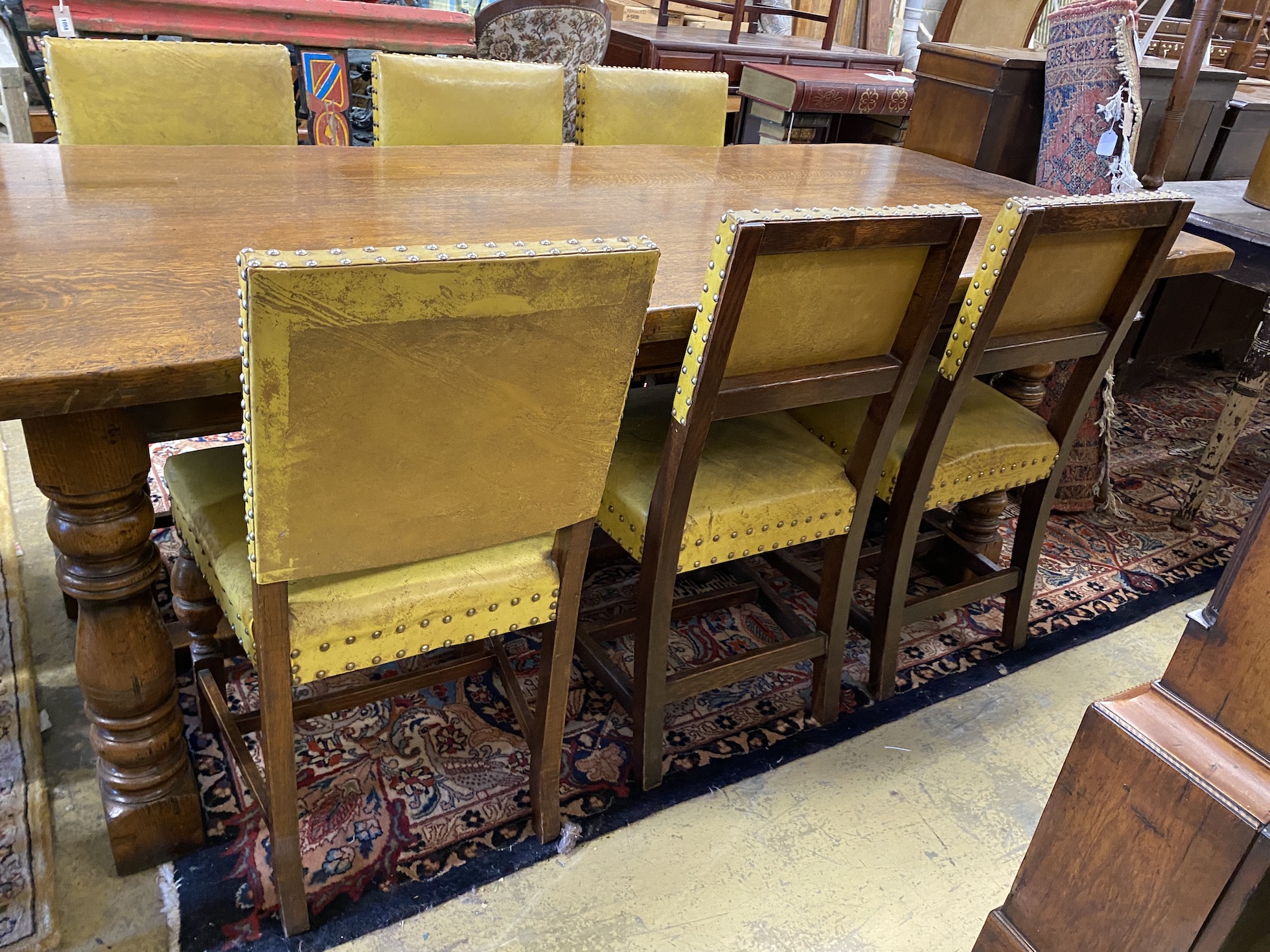 An 18th century style rectangular oak refectory dining table, length 224cm, width 92cm, height 77cm and eight dining chairs (2 with arms)